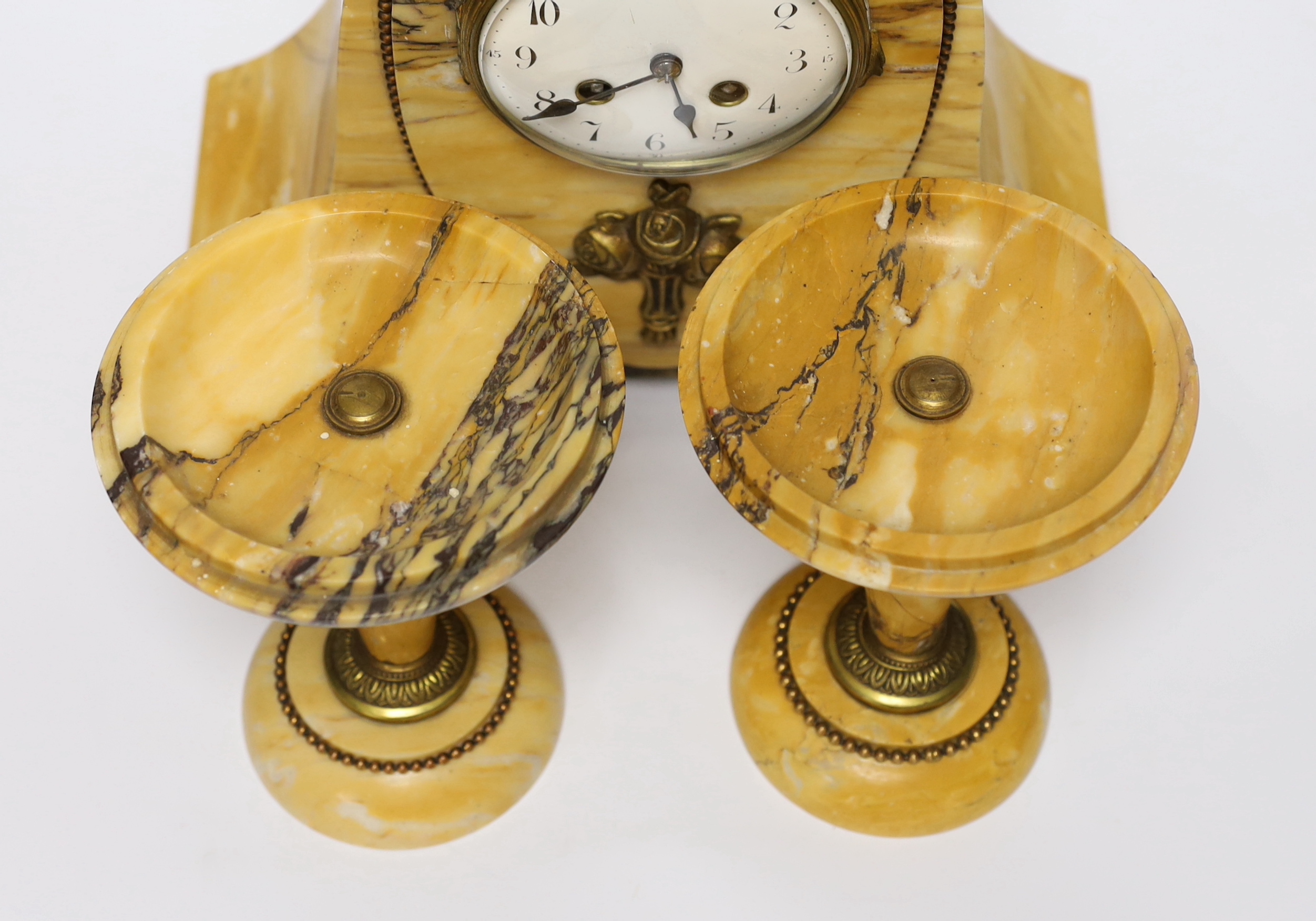 An early 20th century French Sienna marble clock garniture, 30cm